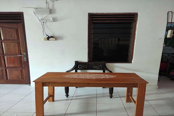 Ein Holztisch mit Tischset, zwei Fenster und eine Wandsteckdose.