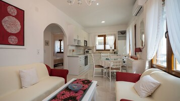 Um espaço compacto para viver, com cozinha compacta, área de refeições e quarto.