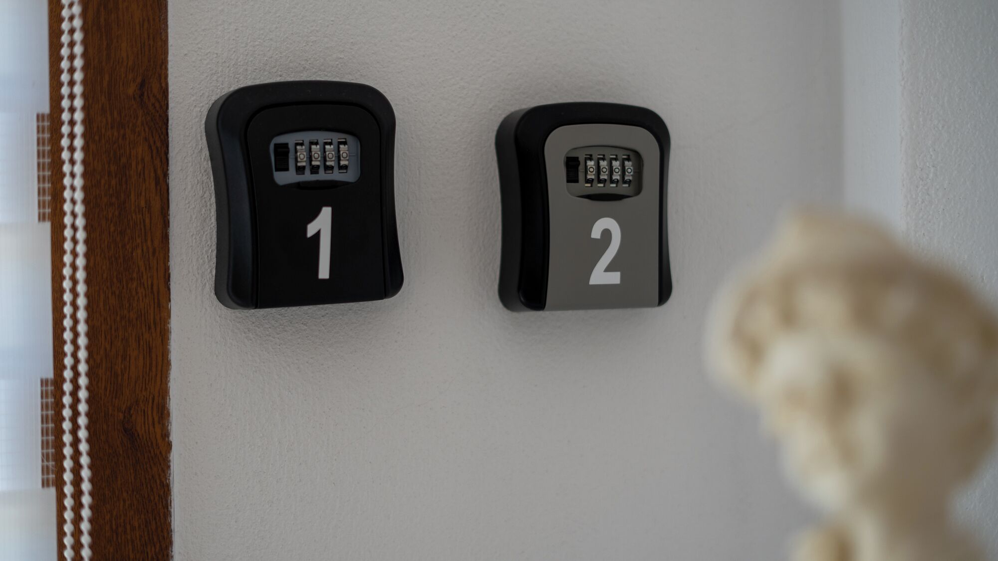 Deux interphones noirs, portant les numéros 1 et 2, sont fixés sur un mur blanc.