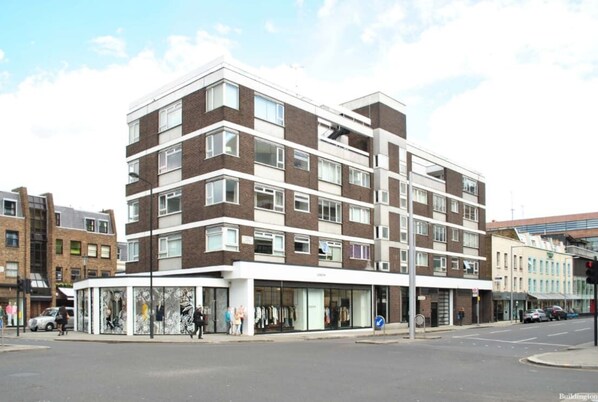 A multi-story building with a modern architectural design, featuring a mix of brick and white facade, large windows, and a ground-level retail space. - The Elden - No.3 (London)