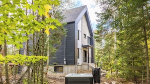 Ein modernes Haus, umgeben von einem Wald.