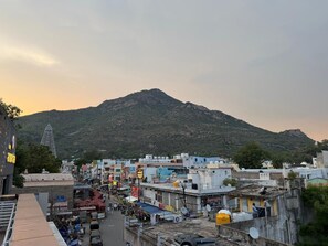 Un pueblo con edificios, una colina al fondo y una estructura grande con un pico.