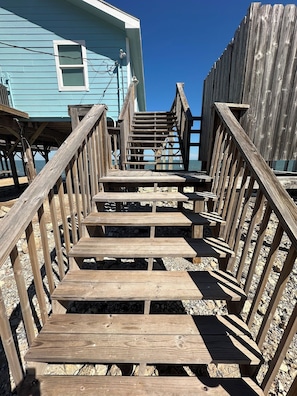 Un escalier en bois mène à une jetée d’où l’on a une vue dégagée sur l’eau.