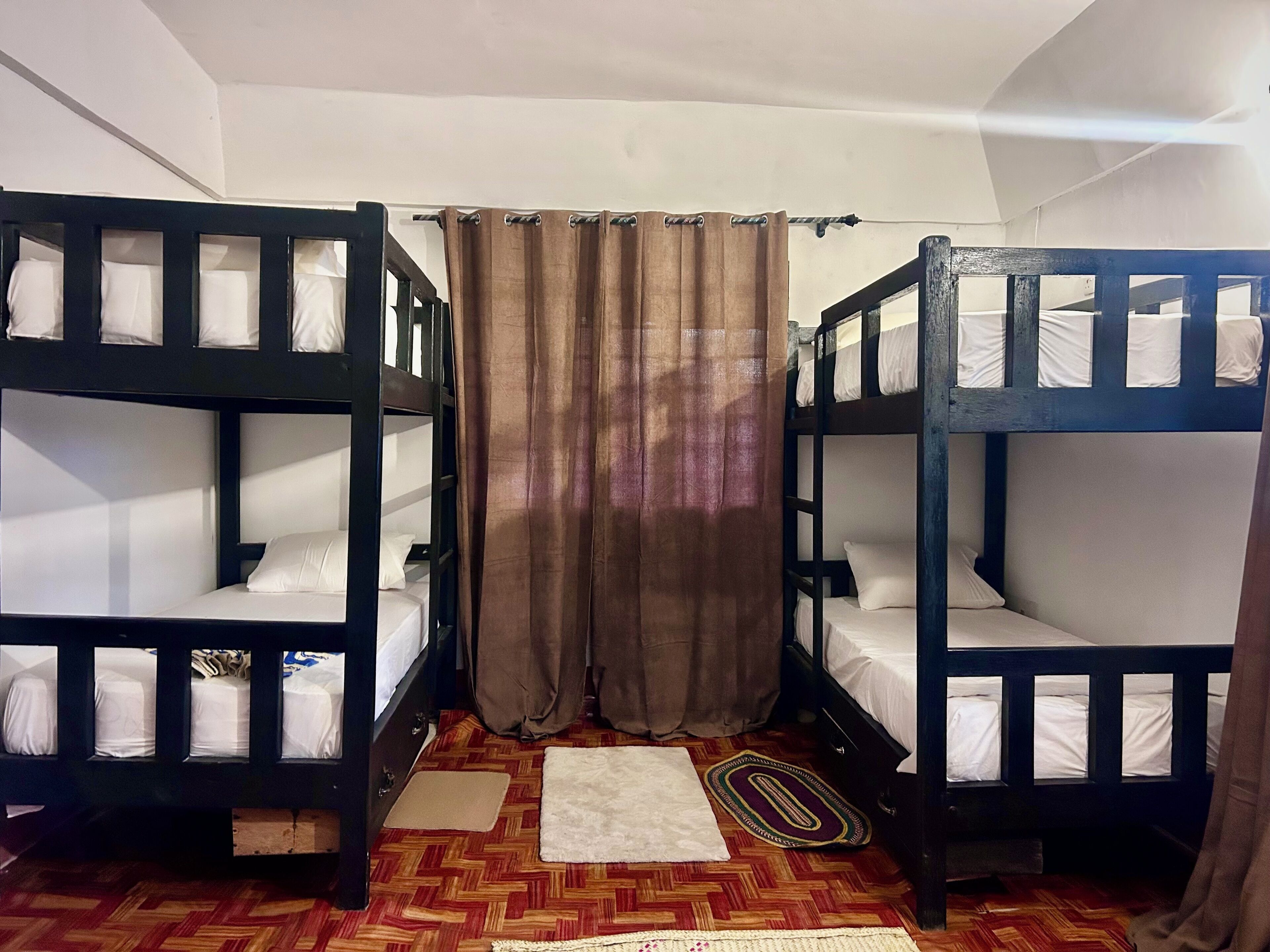 Un dormitorio con literas, una cortina y un suelo estampado.