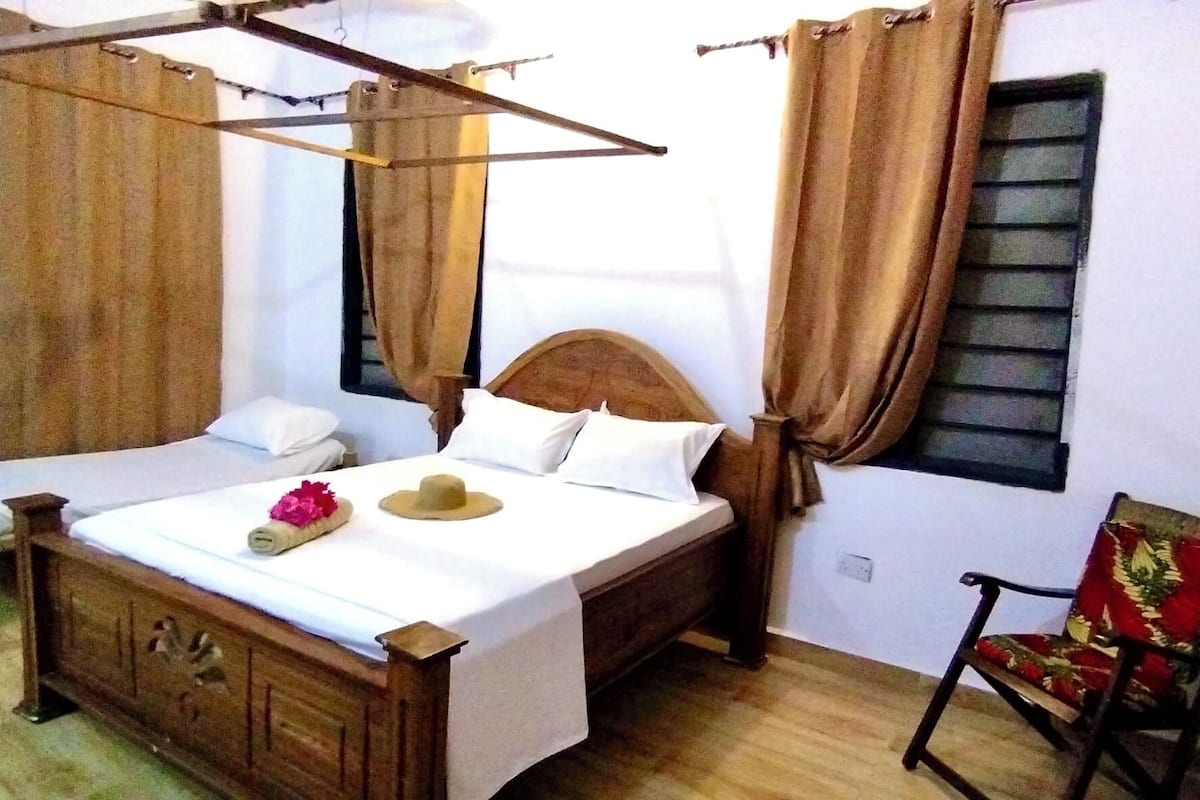 A bed with a wooden headboard, a bedside table, and a chair.