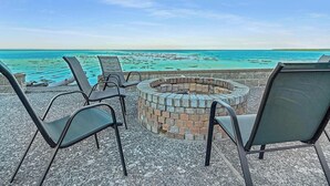 A fire pit surrounded by chairs overlooking a turquoise sea. - Dungeness Waterfront, Hot tub, Fire Pit, Pets OK (Sequim)