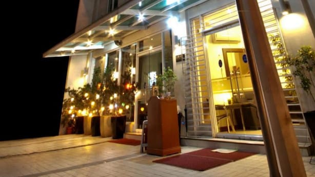 A hotel entrance with a covered outdoor area, potted plants, and a staircase leading to the entrance. - Townhouse OAK Metro Manila Near Osmena Highway PNR Pasay formerly Avitel Hotel (Makati)