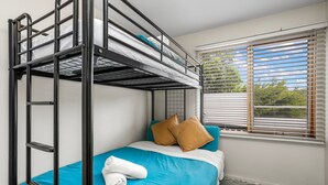 Habitación con literas, una ventana, una toalla y almohadas.