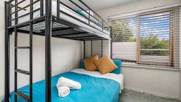 A bunk bed room with a window, a towel, and pillows.