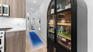 Eine moderne Küche mit integriertem Mikrowellenherd, einem Herd und einem schwarzen Schrank mit Glastüren, der Küchenutensilien zeigt.