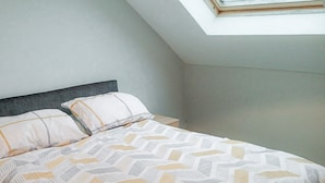 A bedroom with a bed, pillows, and a skylight. - Seamount Holiday Village No 26 (Courtown)
