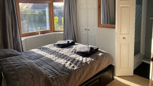 Una camera da letto con un letto, un armadio e una finestra con tende.
