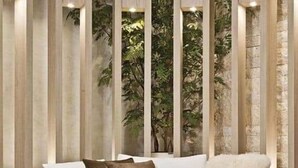 A modern living room with a white sofa, a round coffee table, and a potted plant. - Hotel Maharaja (Nivari)