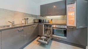 A modern kitchen with stainless steel appliances, a dishwasher, and a built-in oven. - Cozy Stylish Berlin Apartment With 2 Bedrooms (Berlin)