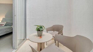 A modern living room with a sofa, a round table with chairs, and a potted plant. - Luxury Studio - Tesoro, Provenza, and Parque Lleras (Medellín)