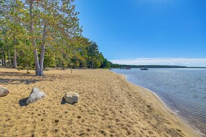 A sandy beach with trees and a calm lake. - 2 Blocks to Boat Ramp: Higgins Lake House w/ Grill (Roscommon)