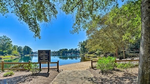 A private beach with a stone pathway leading to the water, surrounded by trees and a wooden fence. - Keowee Key Condo w/ Lake Access! (Salem)