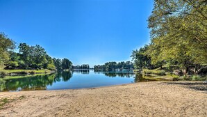 A sandy beach with a calm lake surrounded by trees. - Keowee Key Condo w/ Lake Access! (Salem)
