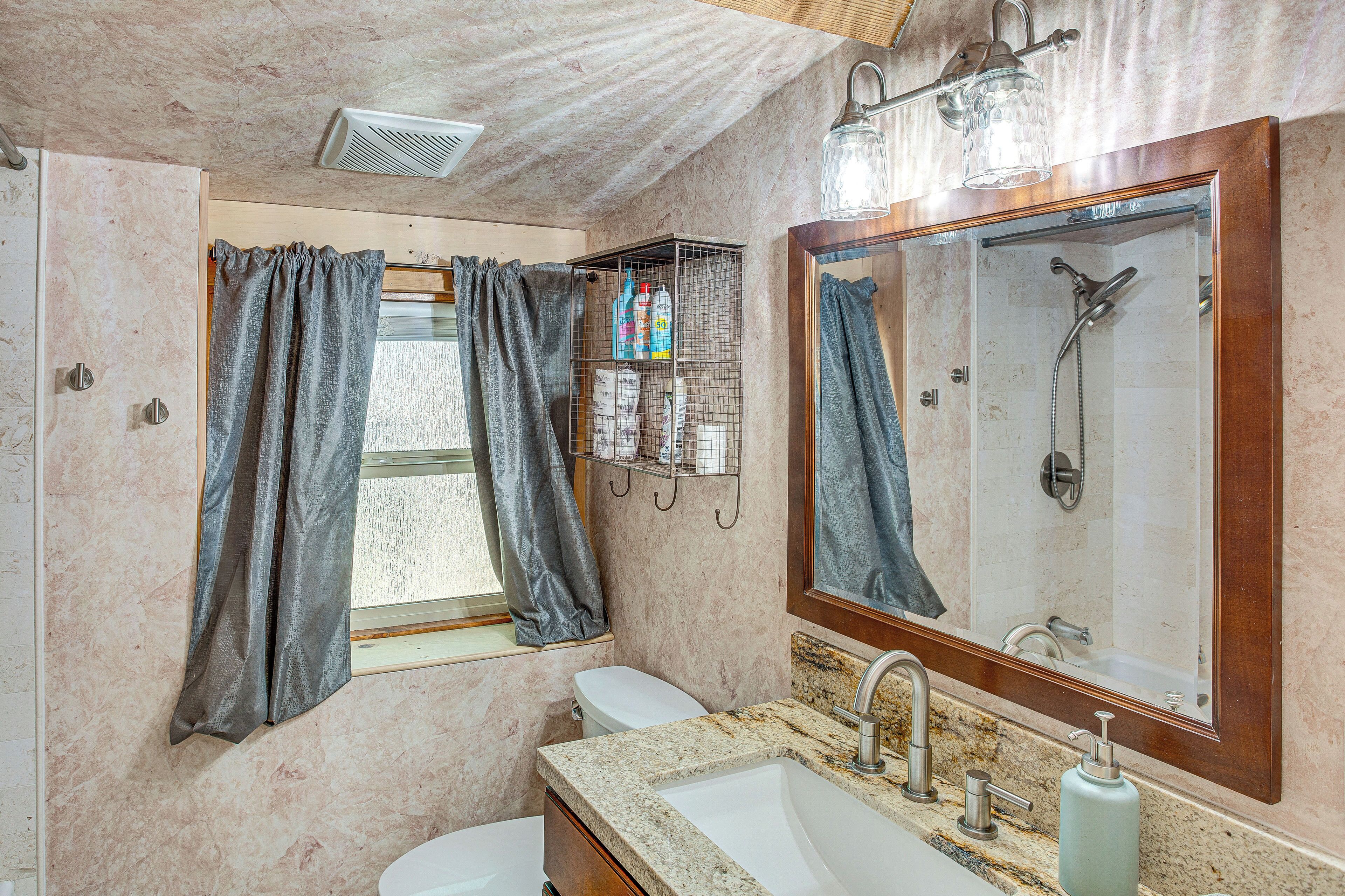 A bathroom with a shower, toilet, and sink.