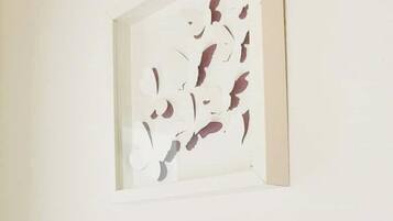 A framed abstract artwork on a plain wall.