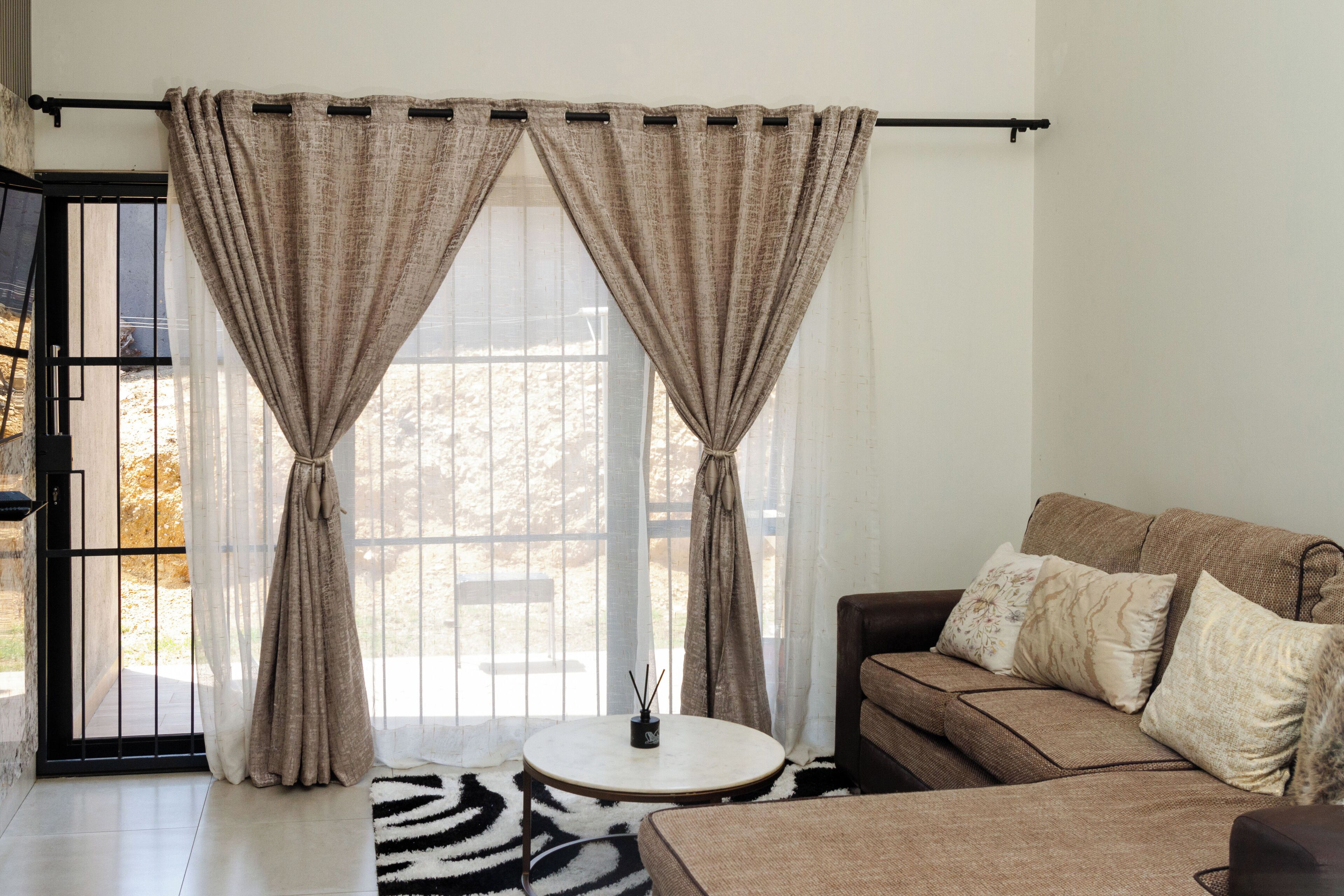 A living room with a sofa, a round coffee table, and a zebra-patterned rug.