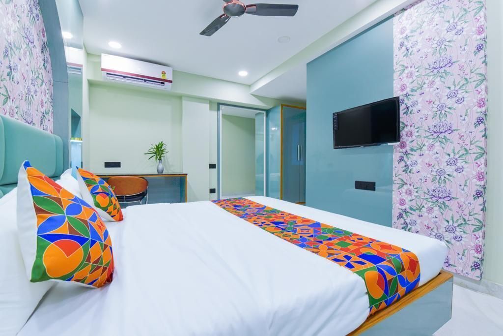 Une chambre d’hôtel équipée d’un lit, d’un bureau, d’une chaise, d’une télévision et d’un ventilateur de plafond.