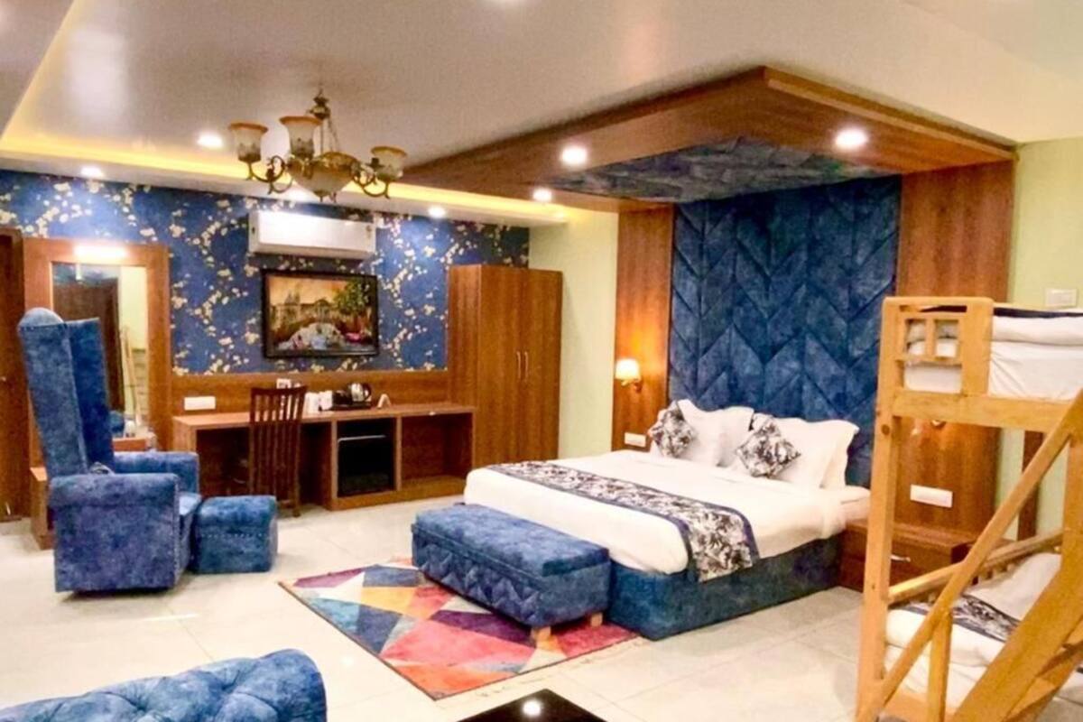 A bedroom with a bed, a desk, a chair, and a bunk bed.