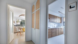 A modern kitchen with wooden cabinets and a dining area with a table and chairs.