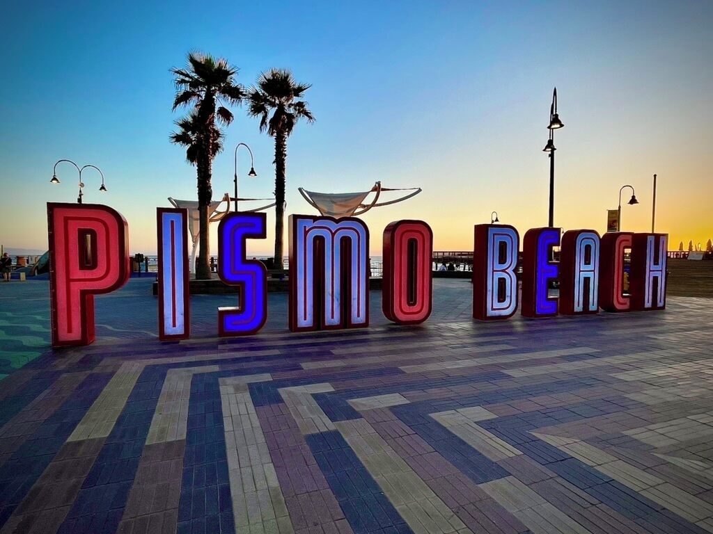 Illuminated letters spelling "PISMO BEACH" on a tiled walkway.