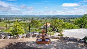 A fountain in a landscaped area with a view of a valley and distant hills. - Hilltop Guest House w/spectacular vineyard views! (Paso Robles)