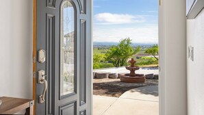A door with a keypad lock, a window with decorative glass, and a view of a landscaped area with a tree and a fountain. - Hilltop Guest House w/spectacular vineyard views! (Paso Robles)