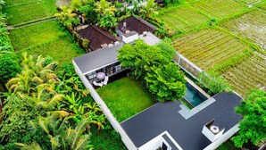 A modern house with a large yard, a swimming pool, and lush greenery. - Loft Volcano by Alfred in Bali - Stylish 2 BR Loft w Pool Garden Ricefields View (Ubud)