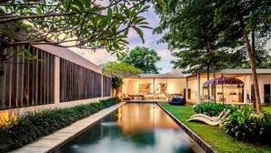 A modern house with a swimming pool, a garden, and a patio area with outdoor furniture. - Loft Volcano by Alfred in Bali - Stylish 2 BR Loft w Pool Garden Ricefields View (Ubud)