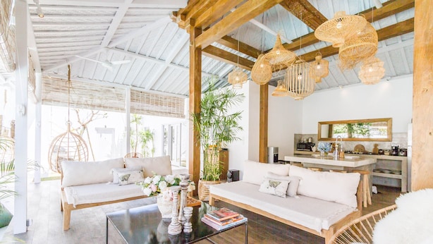 A spacious living area with a wooden ceiling, a sofa set, a coffee table, and wicker hanging lights. - Villa M by Alfred in Bali - Stunning Family Villa With Pool at Seminyak Beach (Seminyak)