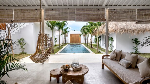 Un espace intérieur moderne doté d’une piscine, d’un fauteuil suspendu, d’un canapé et d’une table basse.
