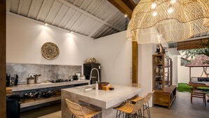 A modern kitchen with a central island, bar stools, and a hanging light fixture. - Villa Folie by Alfred in Bali - New 5bdr Dream Villa in the Heart of Seminyak (Seminyak)