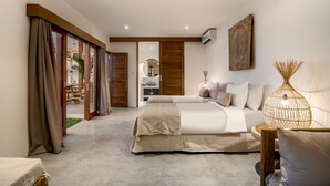 A modern bedroom with a large bed, a sofa, and a dining area visible through a sliding door. - Villa Folie by Alfred in Bali - New 5bdr Dream Villa in the Heart of Seminyak (Seminyak)