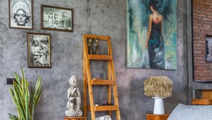A modern living room with a grey sofa, wooden coffee table, and a ladder shelf. There are framed pictures on the wall and a potted plant. - Villa Maje by Alfred in Bali - Tropical 3BD Villa w Pool Near Batu Belig Beach (Seminyak)