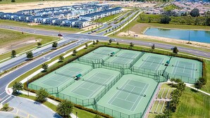 A large tennis court complex with multiple courts, surrounded by a road and residential buildings. - Upstay - Championsgate Home w Hot Tub-pool-cinema (Davenport)