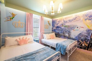 A bedroom with two beds, a chandelier, and a mural on the wall.
