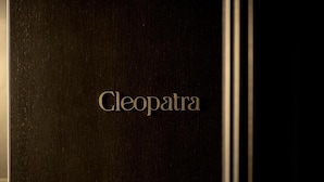 Una porta di legno scuro con la scritta "Cleopatra" incisa in oro.