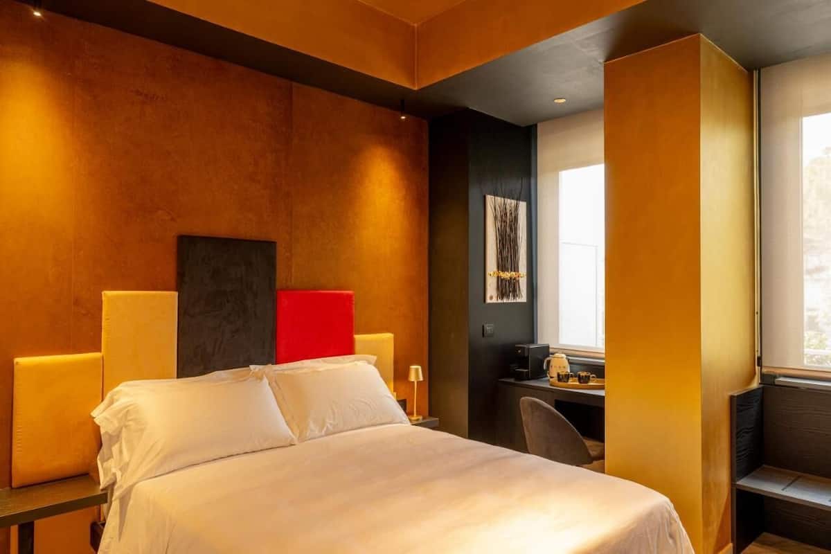 Una habitación de hotel con una cama grande, un escritorio y una ventana.