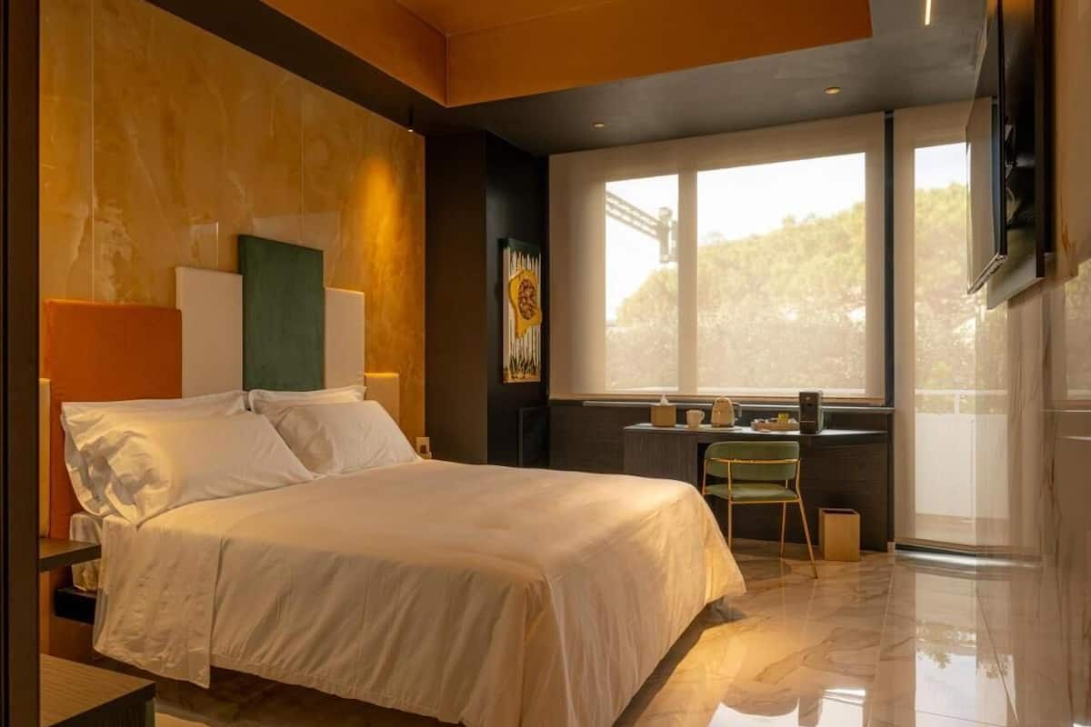 Un dormitorio moderno con una cama grande, un escritorio y una silla.