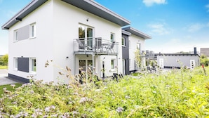 A modern two-story house with a balcony, surrounded by lush greenery. - Vacation residence Hunsrück Hochwald (Mörschied)