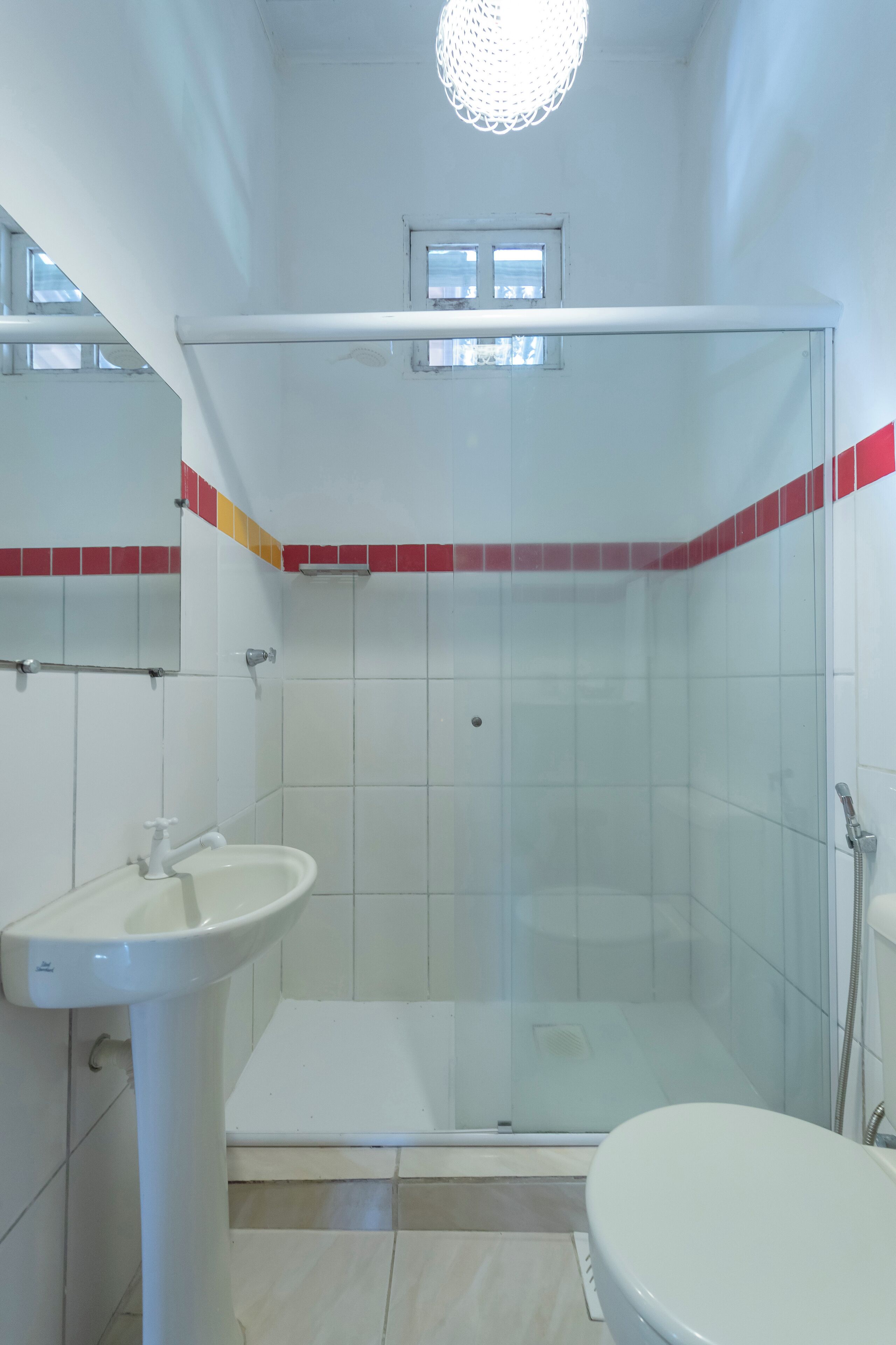 Ein Badezimmer mit Duschkabine, Standwaschbecken und Toilette.