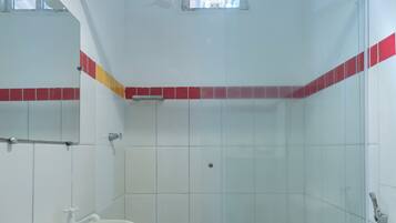 Ein Badezimmer mit Duschkabine, Standwaschbecken und Toilette.