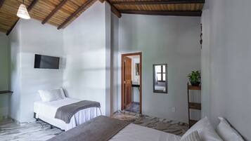 Ein Schlafzimmer mit einem Bett, einem an der Wand montierten Fernseher, einer Holzzieldecke und einem Spiegel.