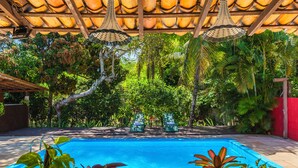 Una piscina con sillas de descanso y plantas en macetas.