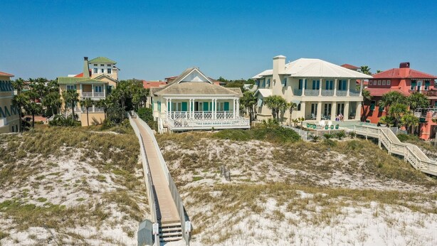 A coastal property with a long boardwalk leading to a house with a balcony. - Sea La Vie 3 Bedroom Home (Miramar Beach)