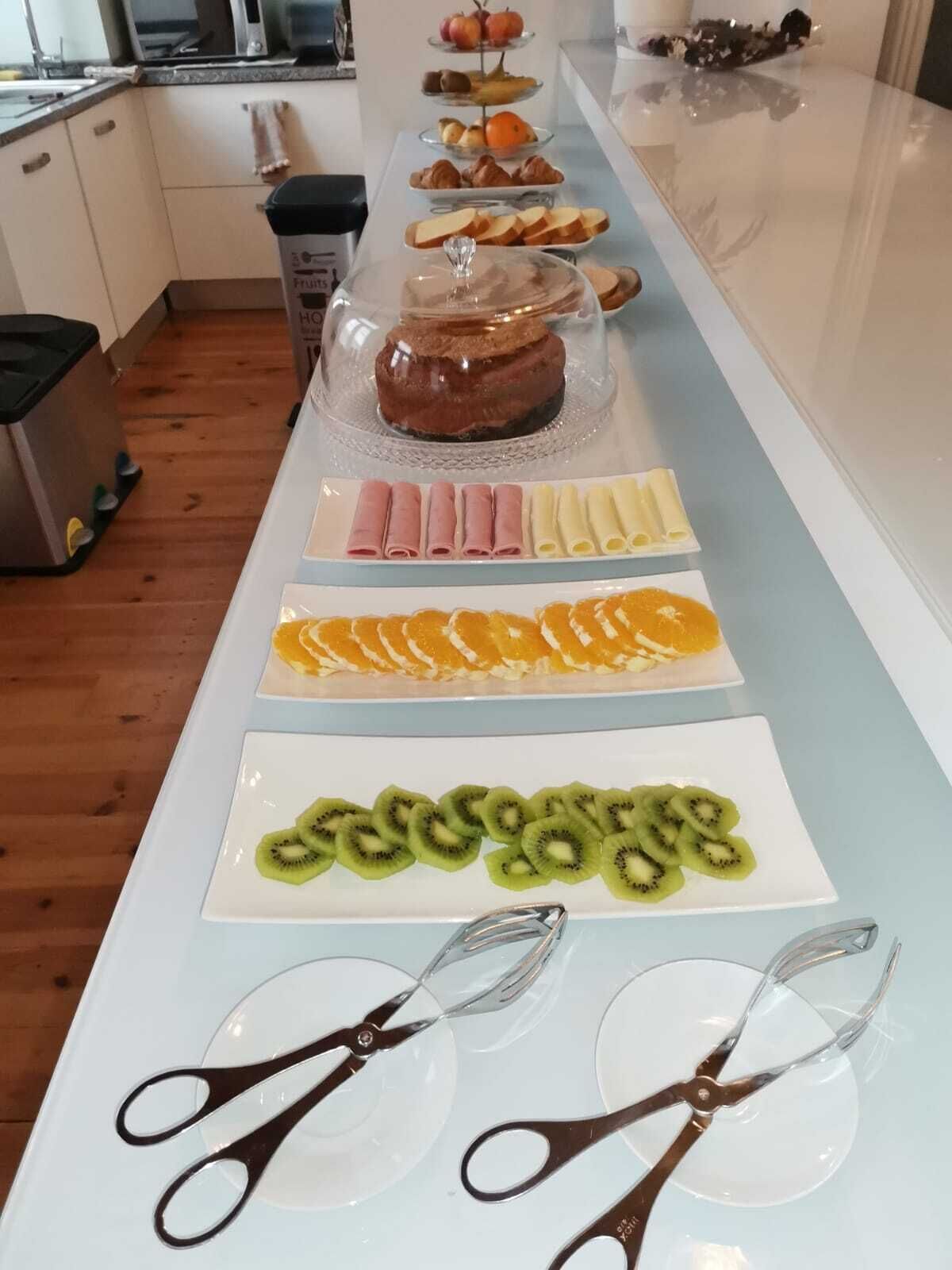 Una mesa de buffet con diversas opciones de comida, como pasteles, frutas y un pastel.